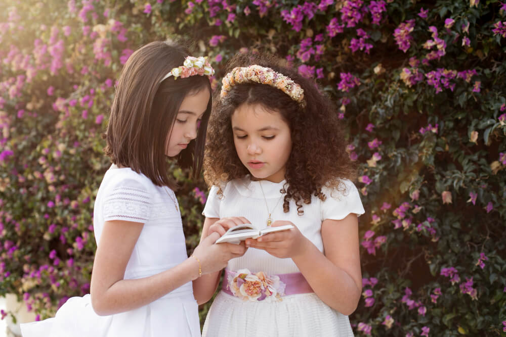 Nomes bíblicos femininos - Duas crianças de branco lendo